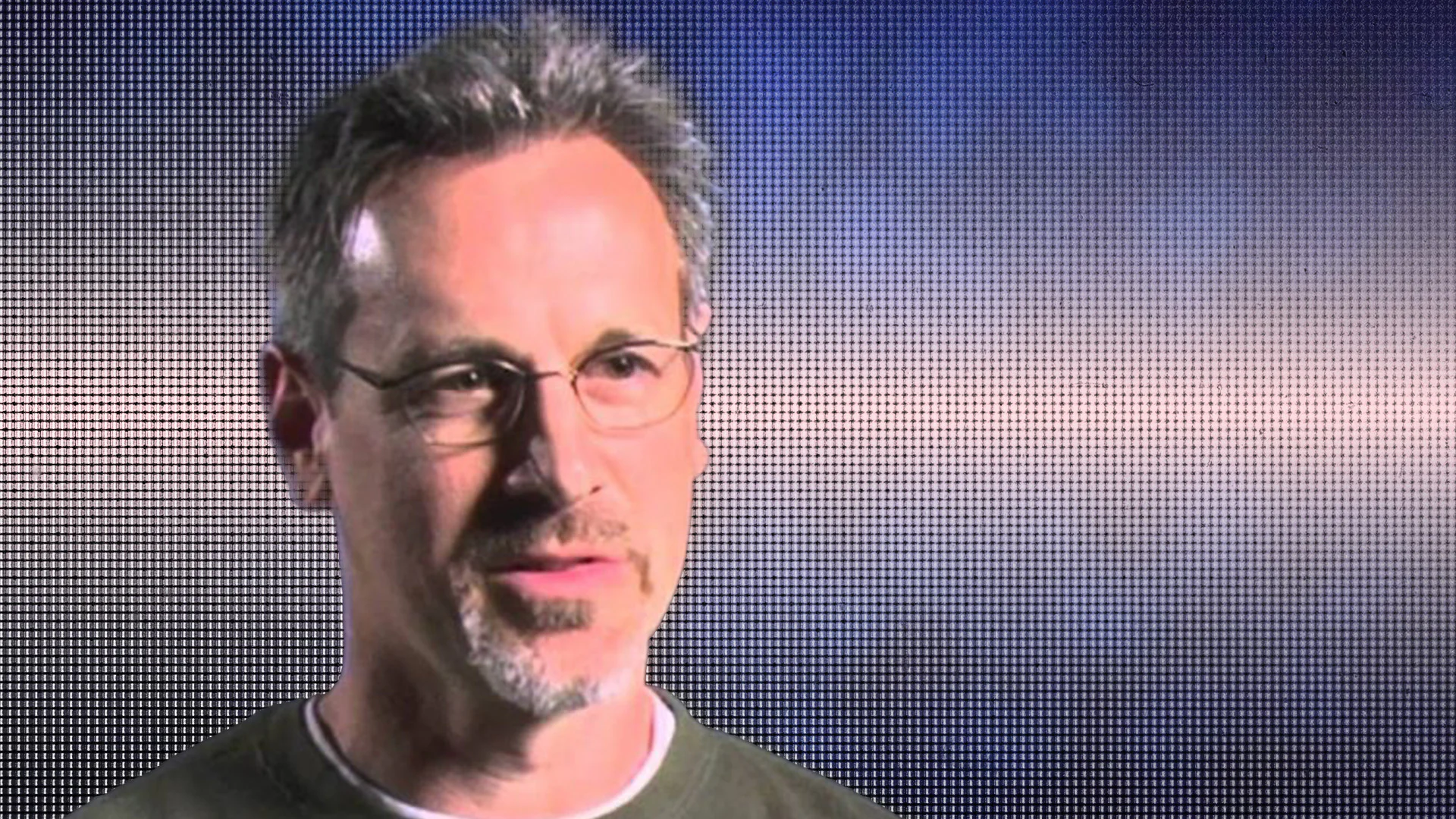 Close-up of a middle-aged man with glasses and a slight smile.