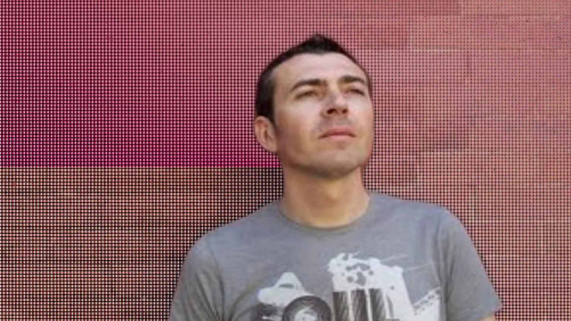 Man gazing at digital LED wall with colorful pixel display.